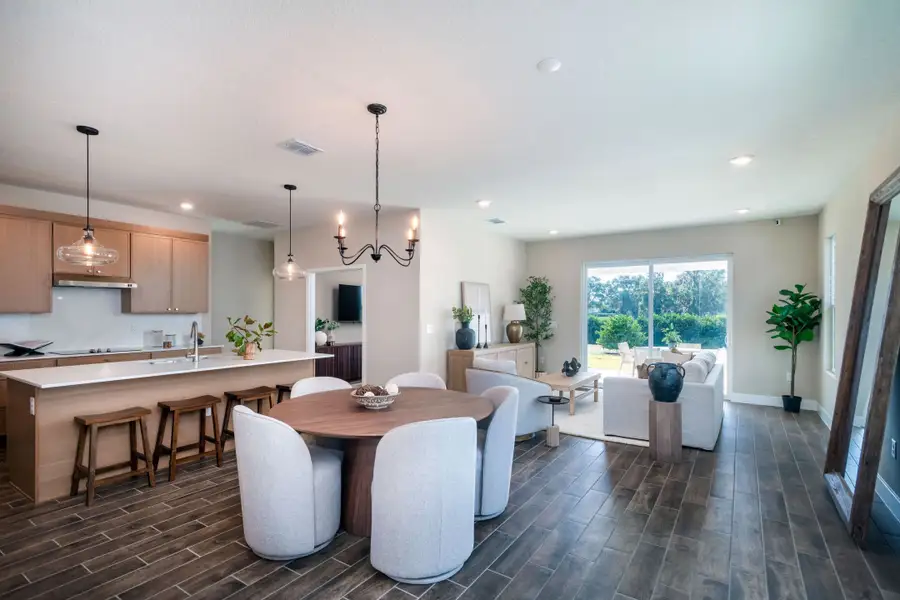 A bright open-concept dining and kitchen area featuring modern finishes, spacious cabinetry, and seamless flow for effortless entertaining. A bright open-concept dining and kitchen area featuring modern finishes, spacious cabinetry, and seamless flow for effortless entertaining.