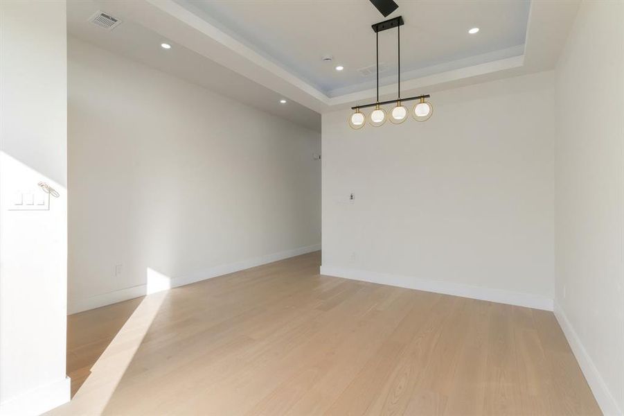 living room 2 featuring light wood-style floors, recessed lighting, and a tray ceiling living room 2 featuring light wood-style floors, recessed lighting, and a tray ceiling