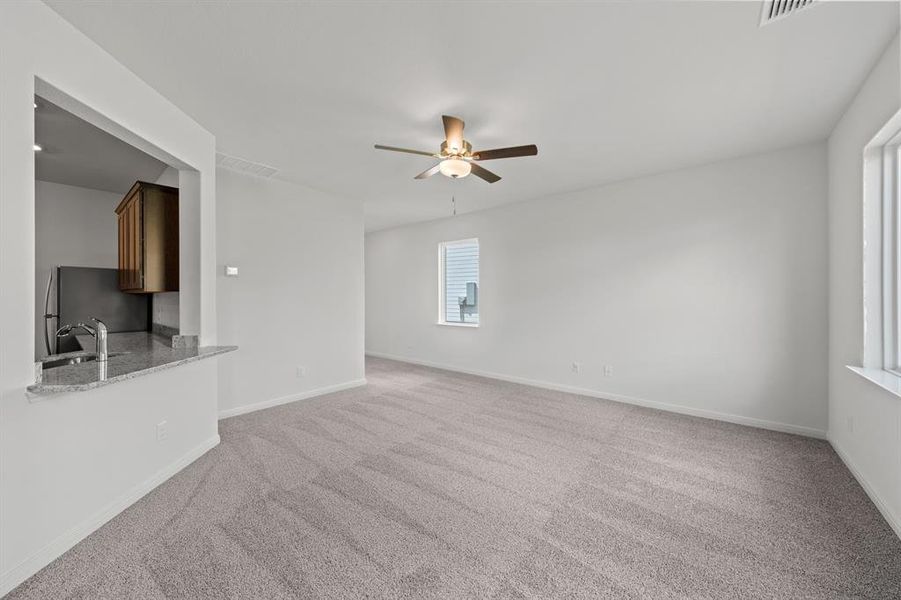 Living room with light carpet and ceiling fan