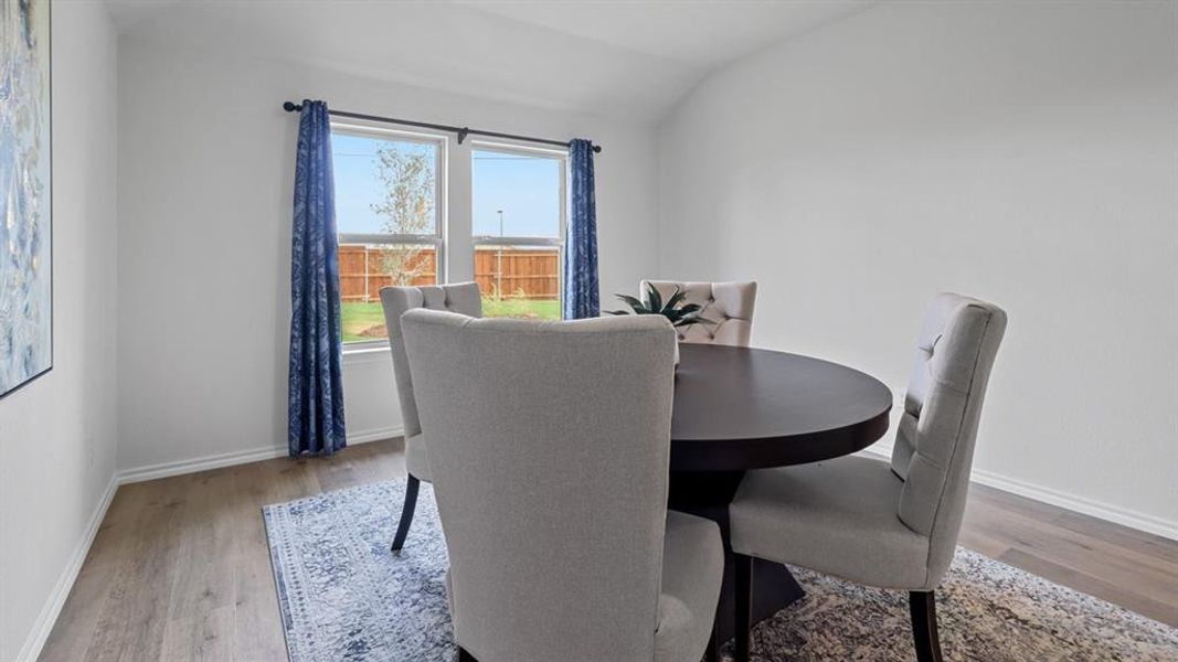 Dining space featuring lofted ceiling and light wood-style floors Dining space featuring lofted ceiling and light wood-style floors
