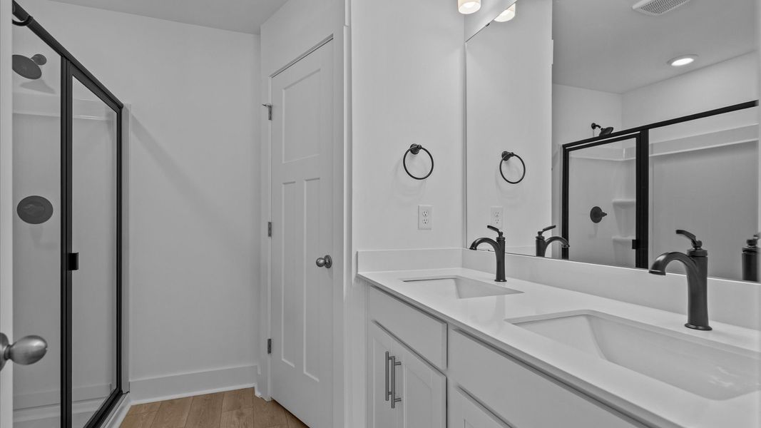 Notable primary bath featuring dual vanity, walk-in shower, and tasteful design touches throughout Notable primary bath featuring dual vanity, walk-in shower, and tasteful design touches throughout