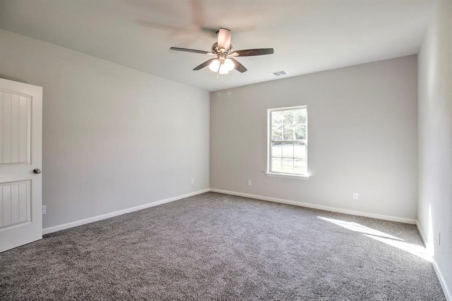 Carpeted spare room with ceiling fan