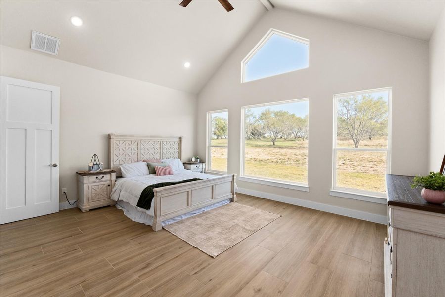 Bedroom featuring high vaulted ceiling, light wood finished floors, ceiling fan, and recessed lighting