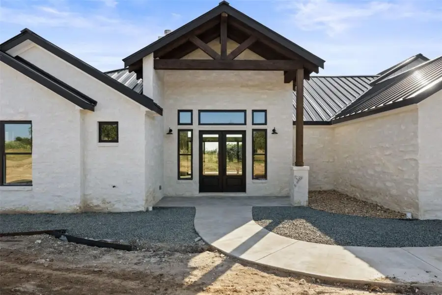 A striking modern farmhouse facade with a deep-set entry porch and bold black accents. A striking modern farmhouse facade with a deep-set entry porch and bold black accents.