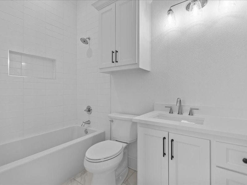 Bathroom with vanity, shower / bathtub combination, and light tile patterned floors