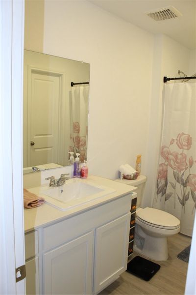 Full bath featuring vanity, light wood-style flooring, and a shower with curtain