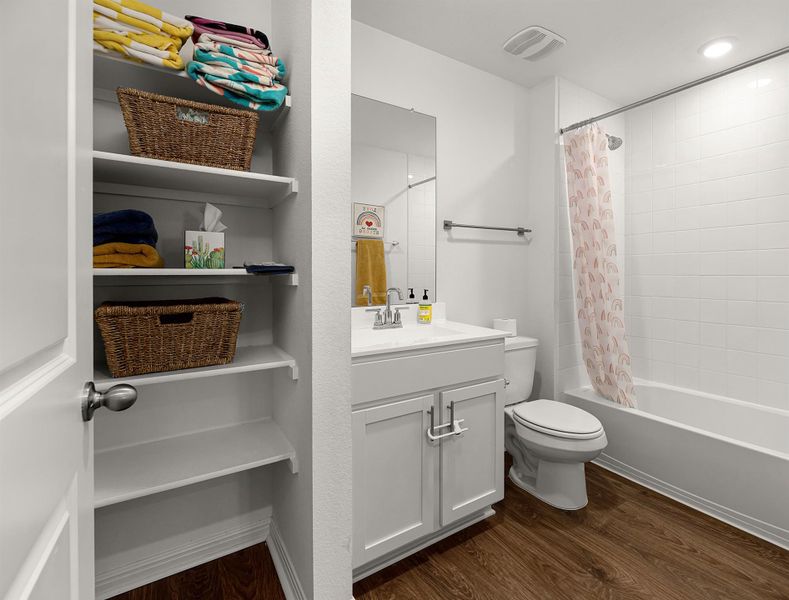 Bathroom featuring vanity, dark wood finished floors, and shower / bath combination with curtain