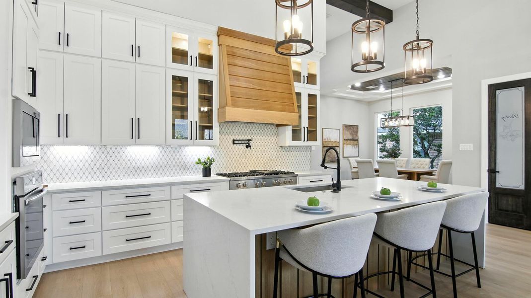 Custom white cabinetry stretching to the ceiling with glass-front accent cabinets on top. Custom white cabinetry stretching to the ceiling with glass-front accent cabinets on top.