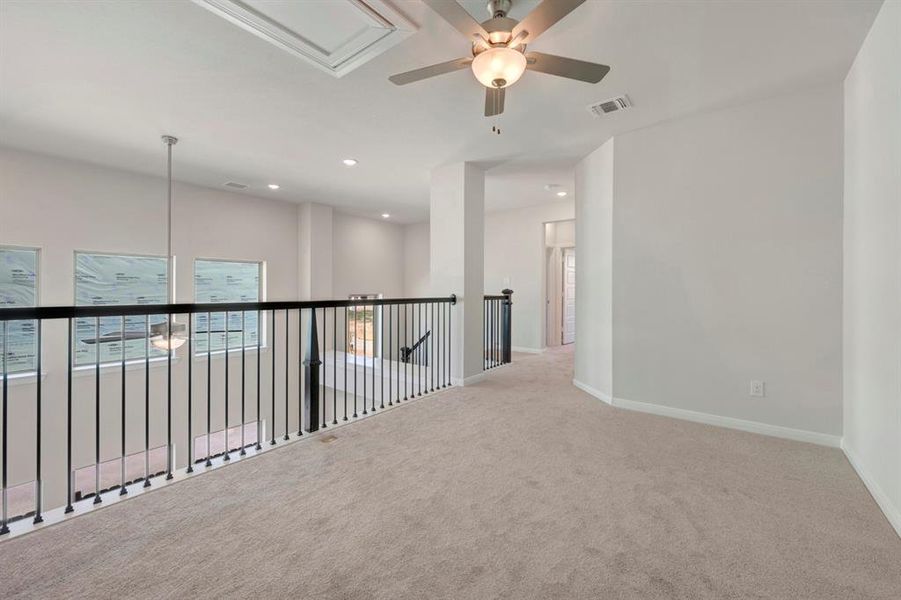 Carpeted spare room with a ceiling fan, plenty of natural light, and recessed lighting