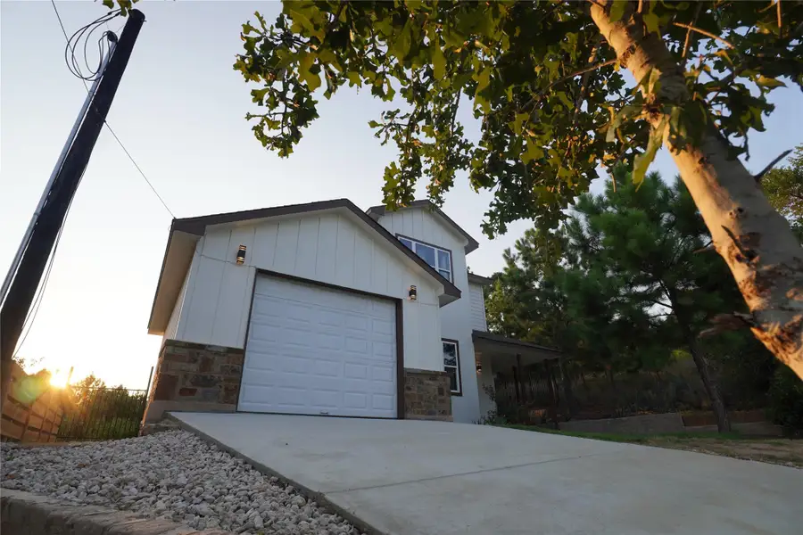 View of home's exterior featuring stone siding, driveway, a garage, and board and batten siding