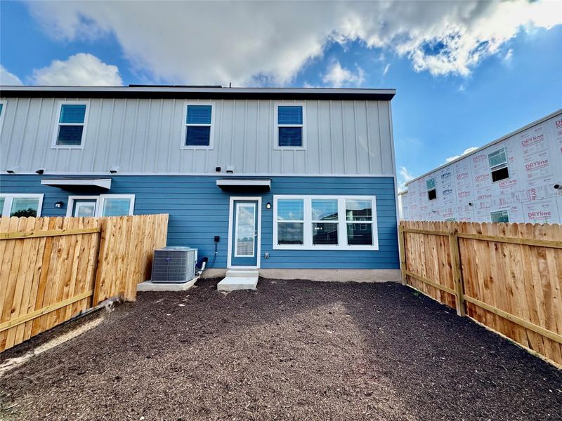 Rear view of property with a fenced backyard and board and batten siding