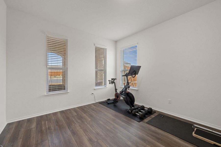Exercise room with wood finished floors and baseboards