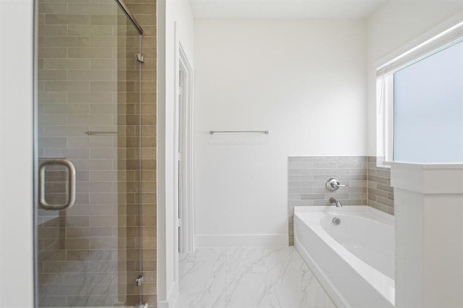 Bathroom featuring a glass-enclosed shower with subway tile, a separate tub with subway tile surround, white walls, and marble-finish flooring