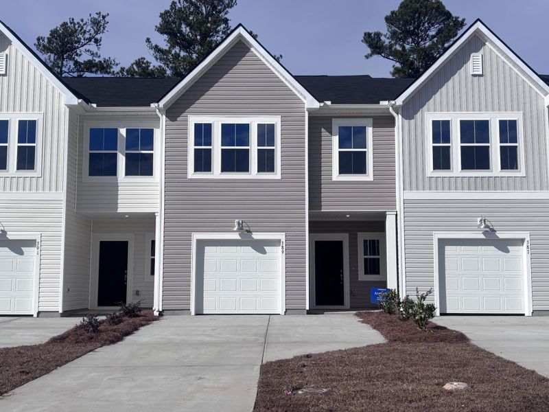 Front exterior of a new home in Lindera Preserve at Cane Bay Plantation: Townhomes, Summerville, SC, highlighting curb appeal (Image 1). Front exterior of a new home in Lindera Preserve at Cane Bay Plantation: Townhomes, Summerville, SC, highlighting curb appeal (Image 1).