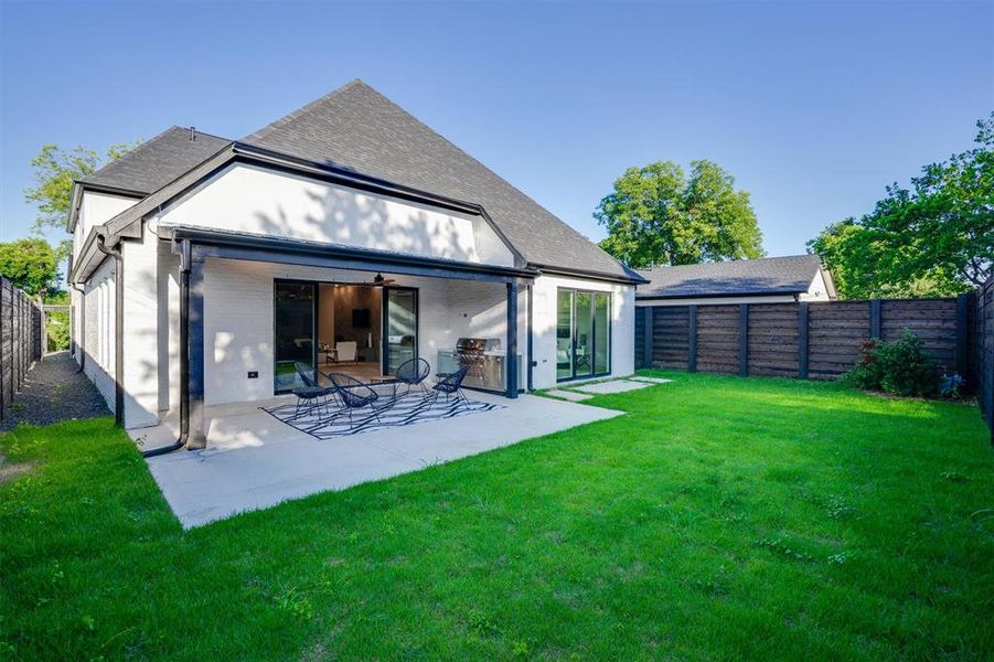 Rear view of house with a patio and a yard