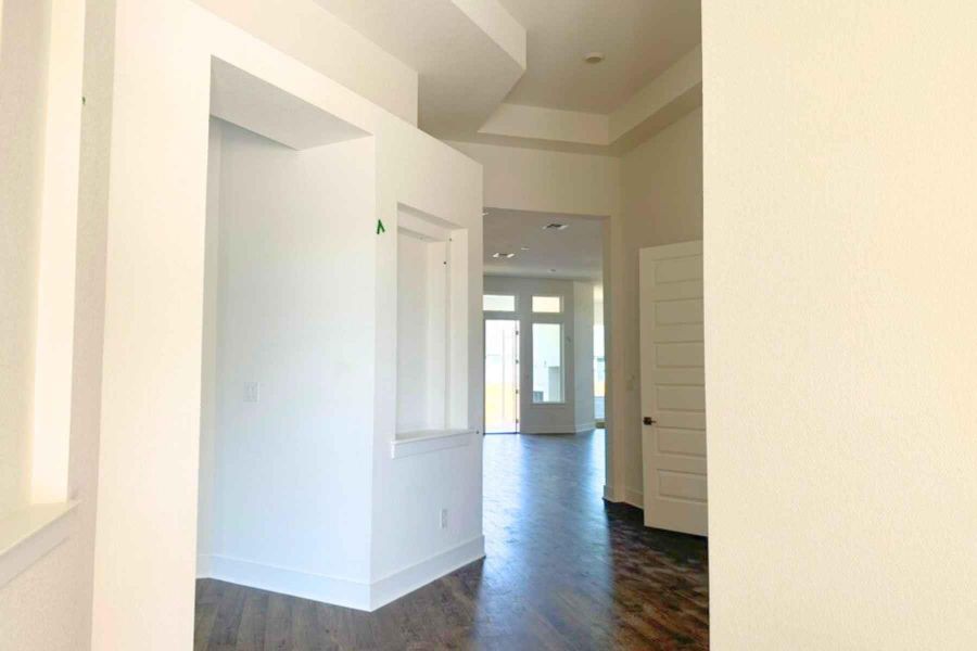 Hall featuring dark wood-style flooring and baseboards Hall featuring dark wood-style flooring and baseboards