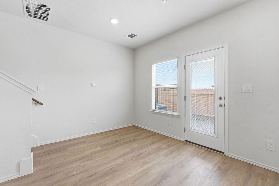 Room with wood-finish flooring, white walls, and recessed lighting Room with wood-finish flooring, white walls, and recessed lighting