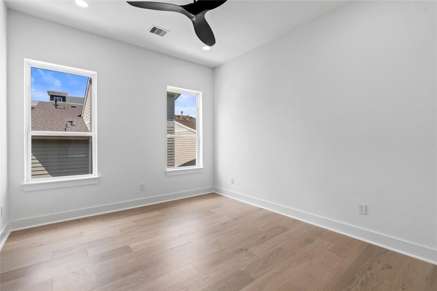 Calm and beautifully proportioned, this secondary bedroom is shaped by twin exposures, lofty ceilings, and gallery-smooth walls that welcome art or built-ins. Recessed lighting and a sculptural ceiling fan keep the look crisply modern, while generous electrical placement anticipates a variety of layouts. A versatile canvas—equally at ease as guest room, nursery, or focused workspace. Calm and beautifully proportioned, this secondary bedroom is shaped by twin exposures, lofty ceilings, and gallery-smooth walls that welcome art or built-ins. Recessed lighting and a sculptural ceiling fan keep the look crisply modern, while generous electrical placement anticipates a variety of layouts. A versatile canvas—equally at ease as guest room, nursery, or focused workspace.