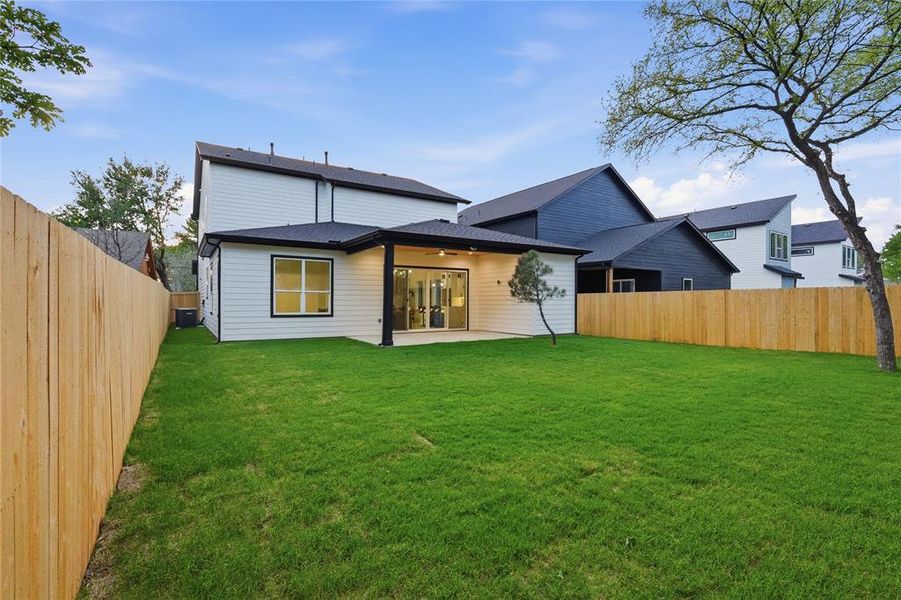 Rear view of house with a fenced backyard, a patio, and ceiling fan
