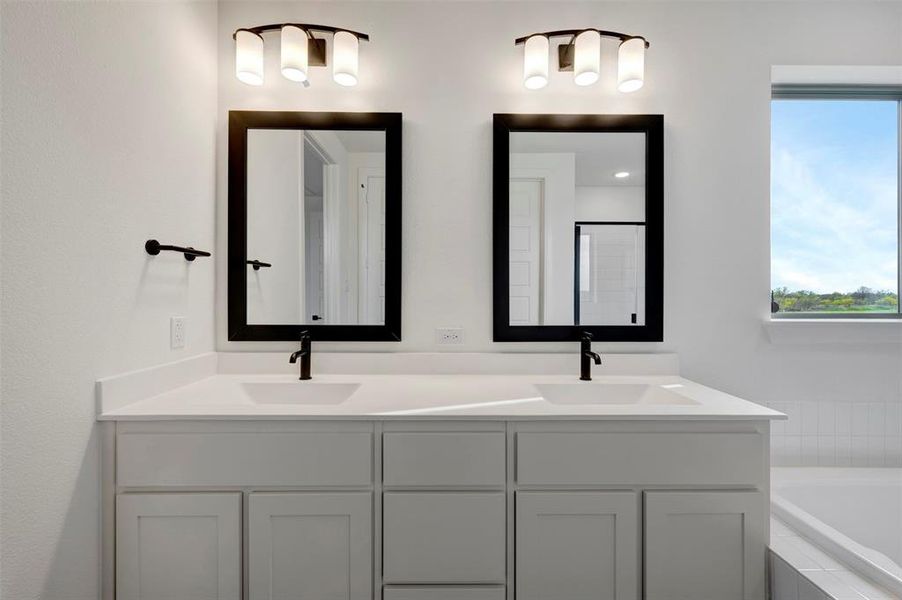 Bathroom featuring double vanity and a garden tub