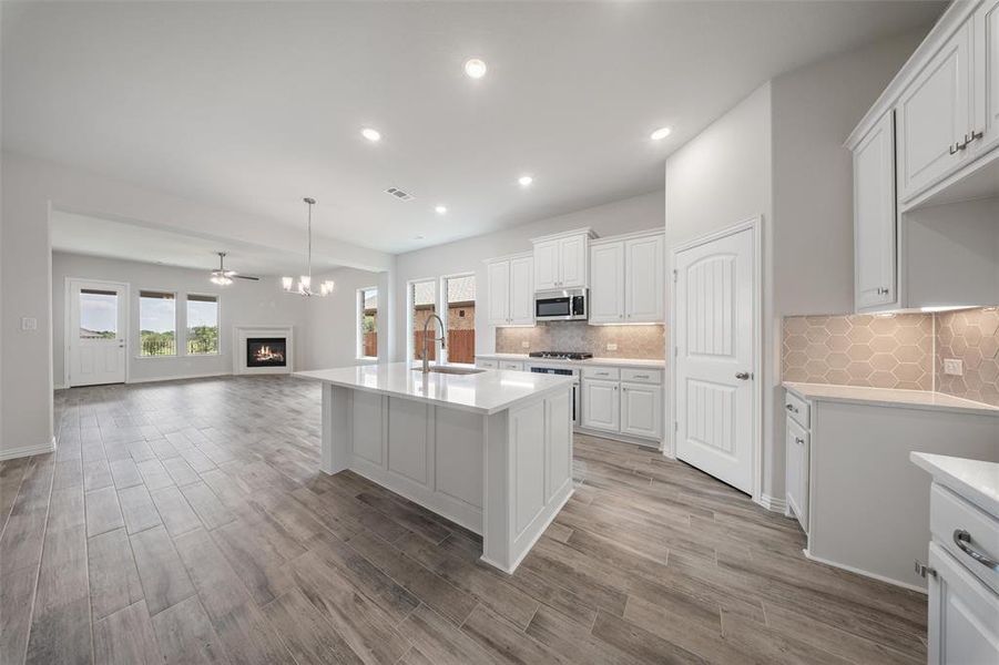 Kitchen with plenty of natural light, light countertops, open floor plan, white cabinetry, and recessed lighting