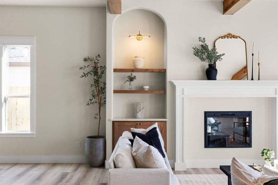 Living room featuring built in features and light hardwood / wood-style floors