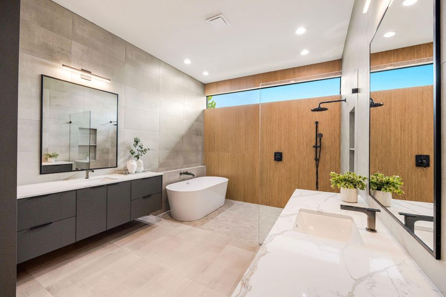 [PRIMARY BATHROOM] The spa-inspired primary bath is a breathtaking showcase of contemporary luxury, where exquisite stone surfaces, designer wall and floor finishes, balanced muted tones, and bold statement fixtures come together in perfect harmony to create an extraordinary retreat.