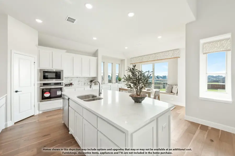 Kitchen with white cabinets, large center island, quartz countertops, stainless appliances, and hardwood floors open to dining area. Kitchen with white cabinets, large center island, quartz countertops, stainless appliances, and hardwood floors open to dining area.