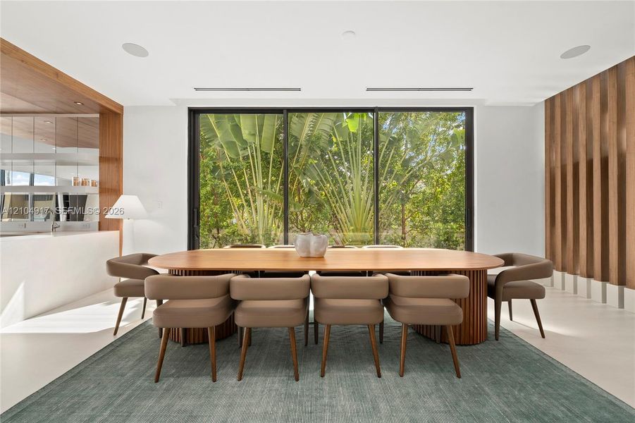 Floor-to-ceiling glass doors, wood-slat accent wall, recessed lighting, and a built-in counter