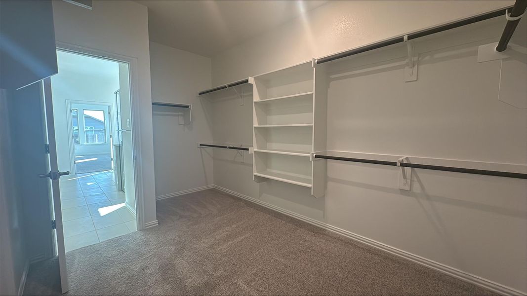 Walk in closet featuring light carpet and light tile patterned floors