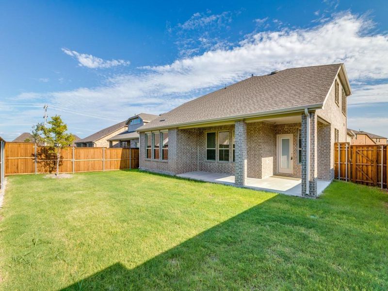 Rear view of property with a patio area, brick siding, a fenced backyard, and roof with shingles