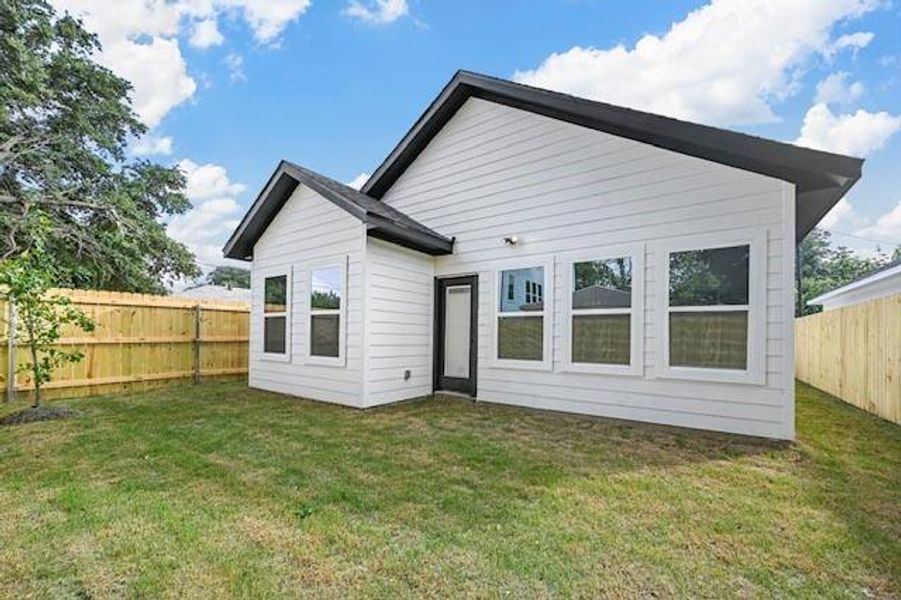 Rear view of house featuring a yard