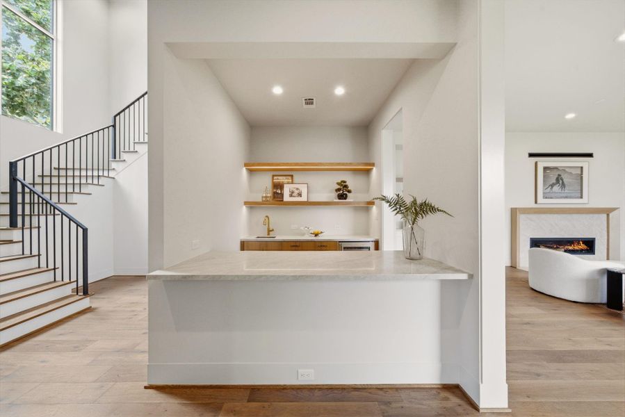 Greeted with a custom  wet bar, an ideal setup for entertaining in style.