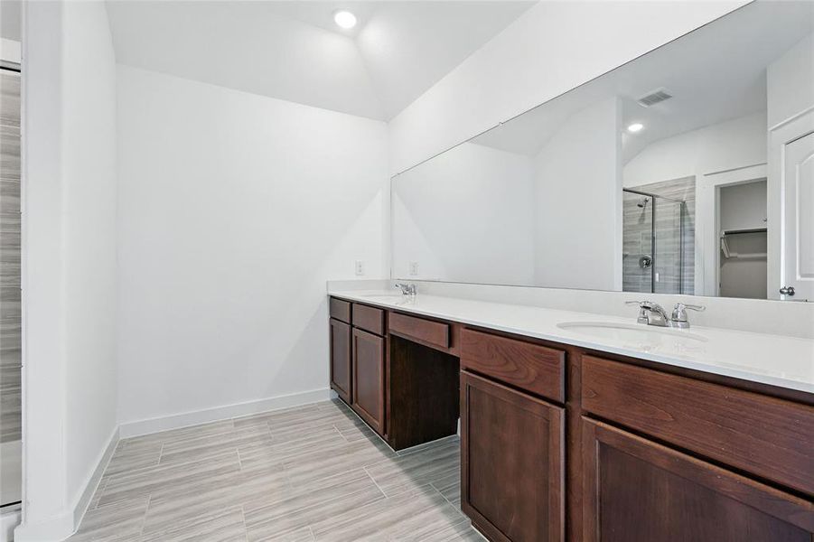 Bathroom featuring a stall shower, double vanity, recessed lighting, and wood finish floors Bathroom featuring a stall shower, double vanity, recessed lighting, and wood finish floors