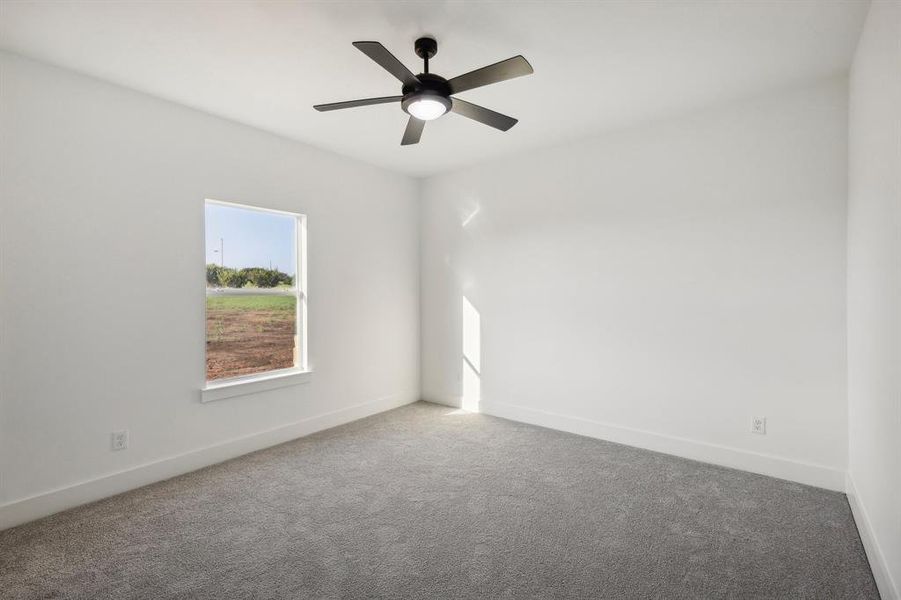 Carpeted spare room with ceiling fan