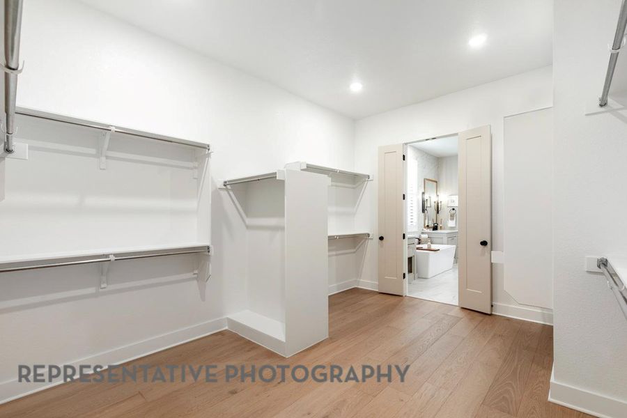 Walk in closet featuring light wood finished floors Walk in closet featuring light wood finished floors