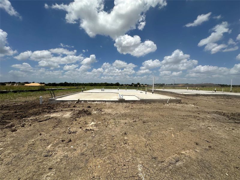 A new construction site with poured concrete foundations awaits future development. A new construction site with poured concrete foundations awaits future development.