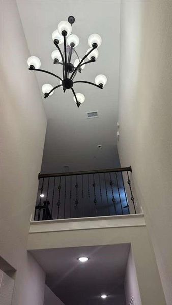 Stairway featuring a chandelier and a high ceiling