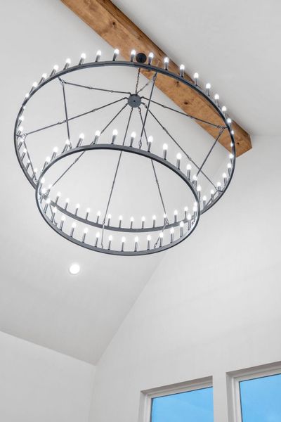 Two-tiered chandelier with multiple light sources and a dark metal frame