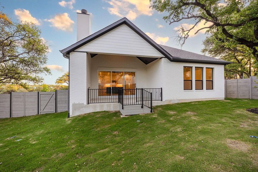 Back of house at dusk featuring a chimney and brick siding Back of house at dusk featuring a chimney and brick siding