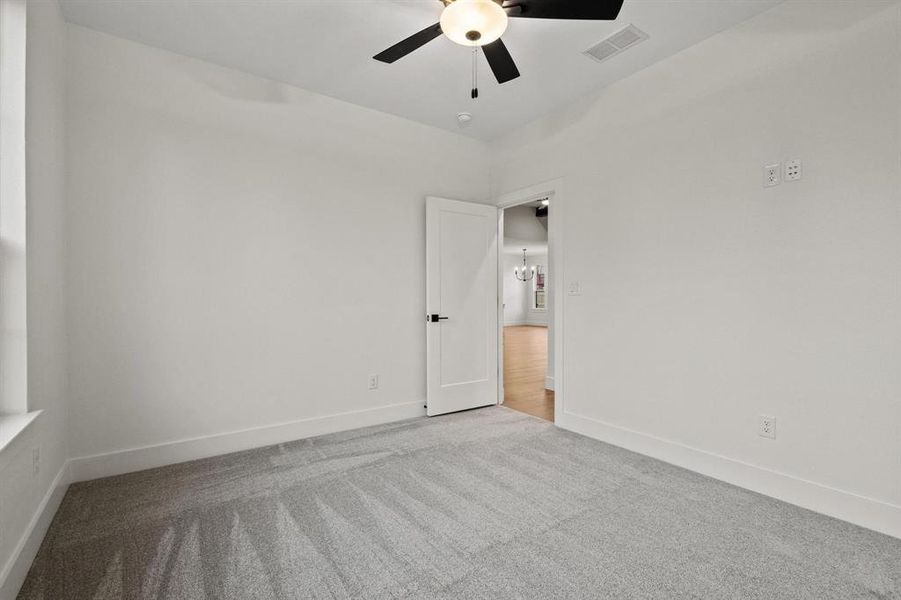 Spare room featuring carpet floors and a ceiling fan