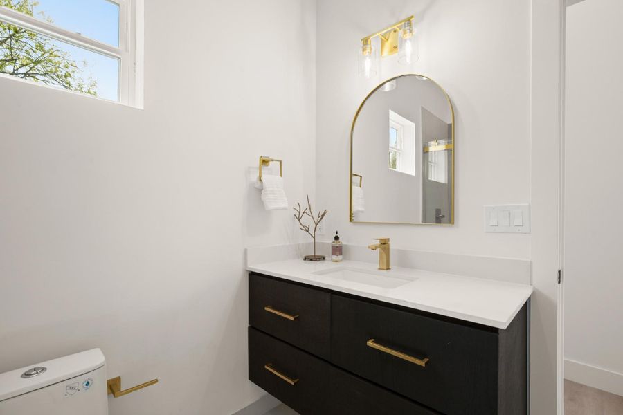 Half bathroom featuring vanity and toilet