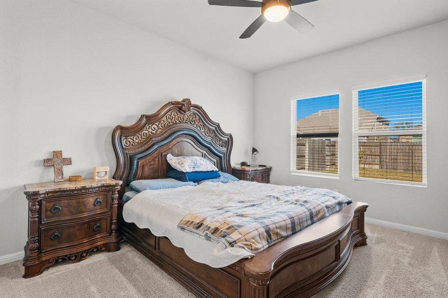 Bedroom with light carpet and a ceiling fan