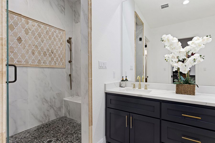 Full bath featuring a marble finish shower and vanity Full bath featuring a marble finish shower and vanity