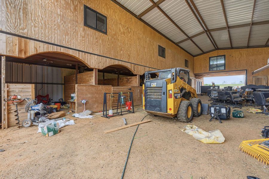 A spacious barn provides ample storage and work areas with durable plywood construction and a sturdy metal roof.