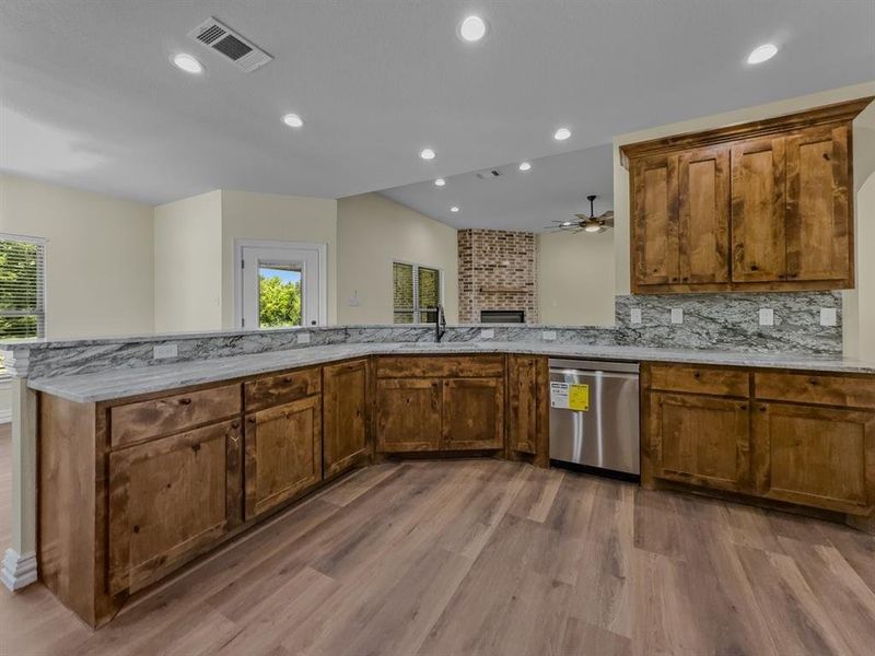 Kitchen with light wood-style flooring, dishwasher, recessed lighting, light stone countertops, and a ceiling fan Kitchen with light wood-style flooring, dishwasher, recessed lighting, light stone countertops, and a ceiling fan