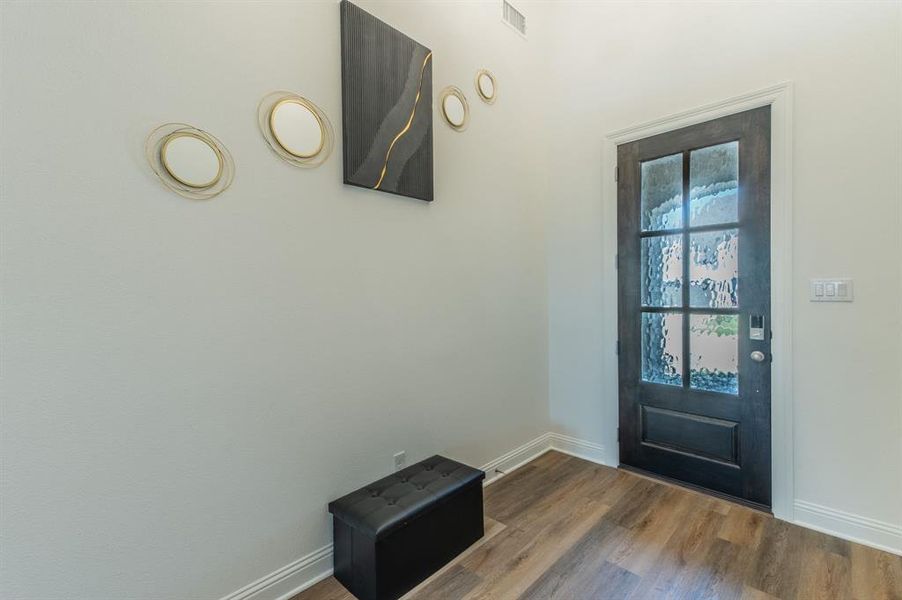 Foyer featuring a dark wood-finish entry door with six privacy glass panes and a smart lock system
