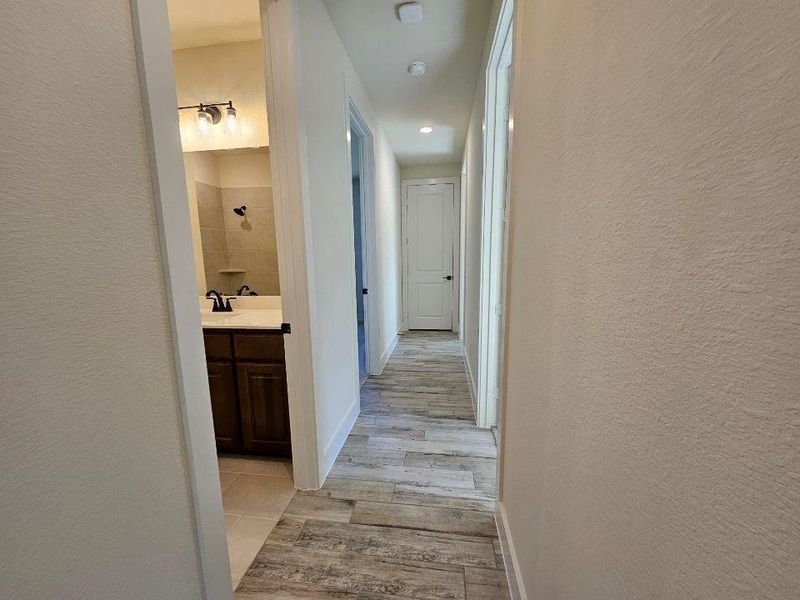 Hallway with a textured wall and recessed lighting