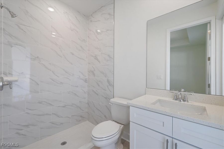 Bathroom with a marble finish shower and vanity Bathroom with a marble finish shower and vanity