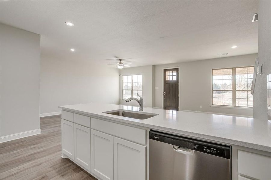 Kitchen featuring stainless steel dishwasher, recessed lighting, light wood finished floors, white cabinetry, and a ceiling fan